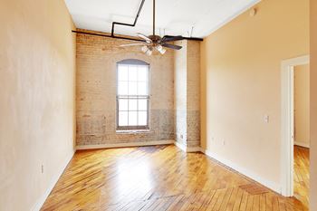 A room with a window and a ceiling fan.